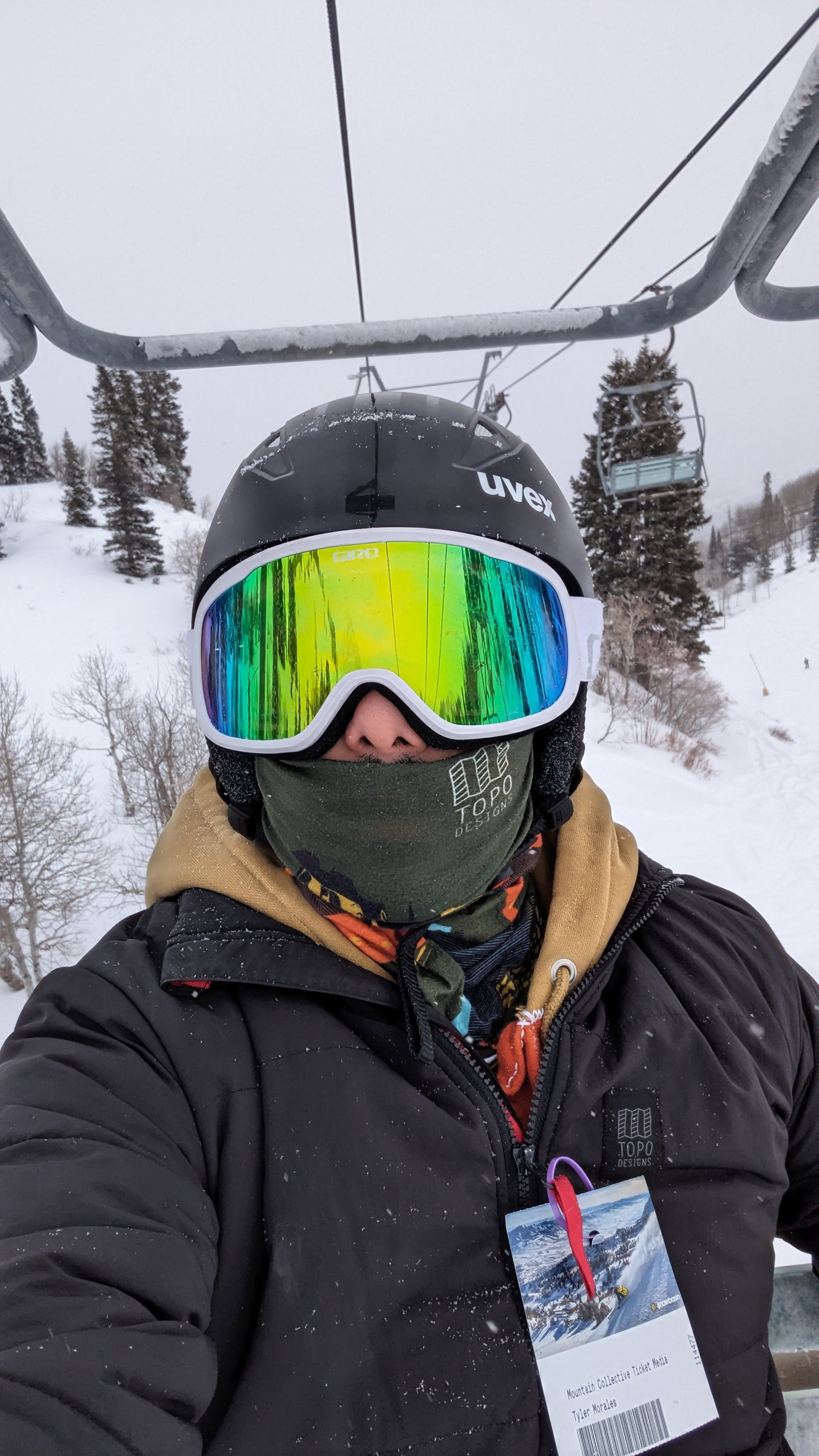 Tyler on a ski lift, wearing ski goggles and winter sports gear.